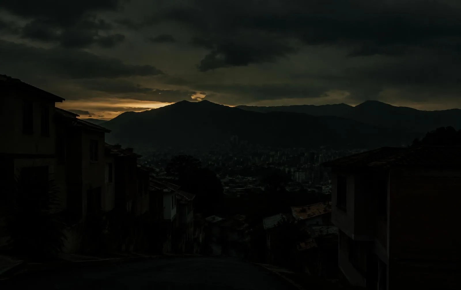 Silueta de una casa y un vecindario en penumbra durante el crepúsculo.